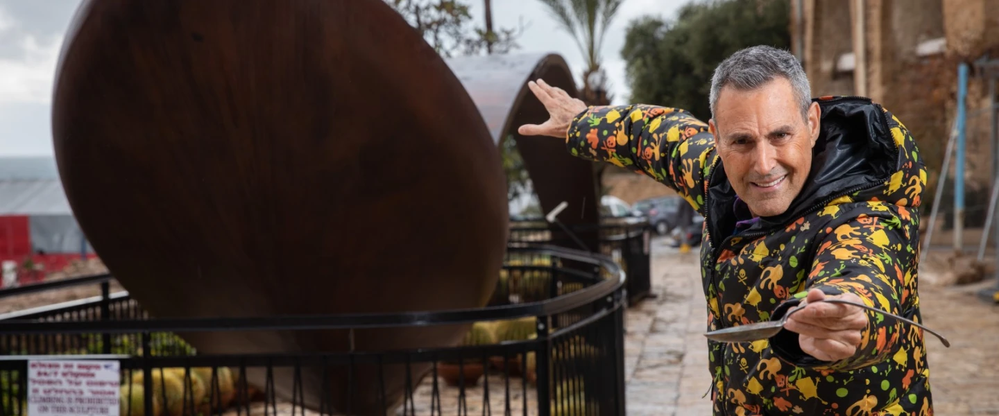 Uri Geller next to a giant bent spoon outside his museum in Jaffa. Photo by Hadas Parush/Flash90.