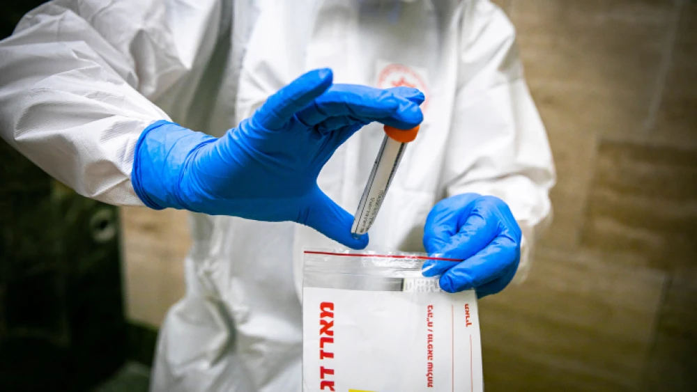 A Magen David Adom medical team member handles a coronavirus test sample in Jerusalem on April 17, 2020. Photo by Olivier Fitoussi/Flash90.