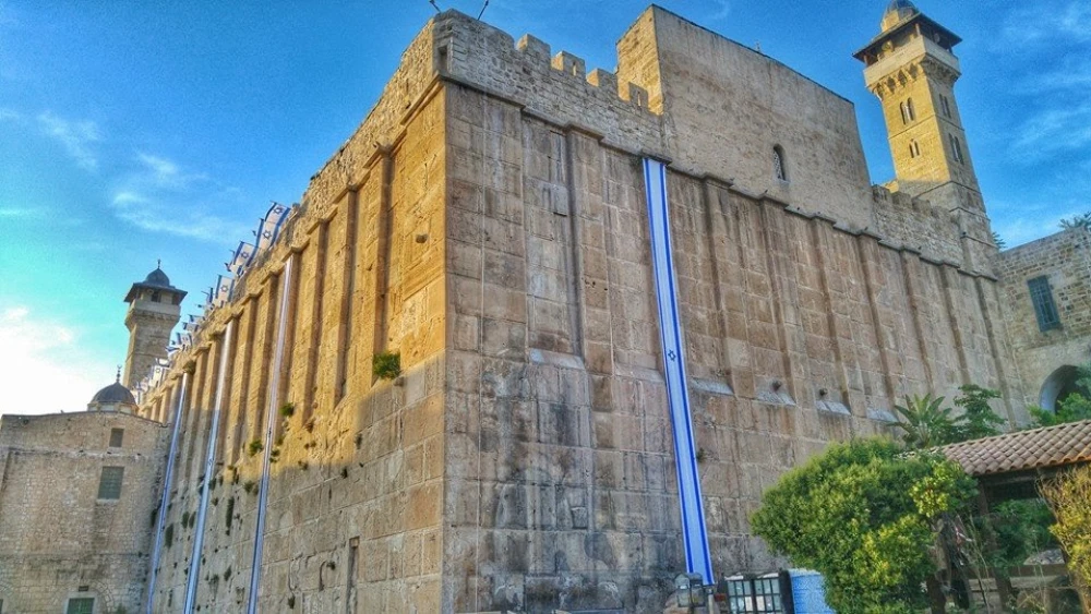 Israel flags decorate the 2,000-year-old Cave of the Patriarchs complex in Hebron in anticipation of Independence Day, May 2018. The same Herodian masonry is used for the Western Wall in Jerusalem. Photo by Yishai Fleisher.