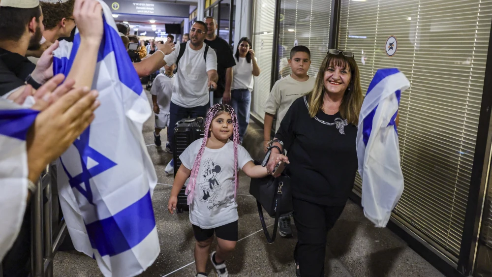 Passengers from flydubai flight #FZ1073 walk with their family members through the arrivals hall at Ben-Gurion International Airport after their original flight from Dubai to Israel was diverted to Saudi Arabia following a suspected terror attack, Sept. 30, 2026. Photo by Flash90.