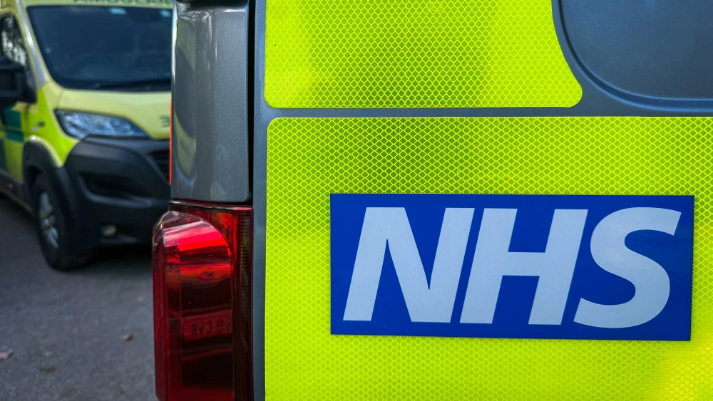 The NHS logo is displayed on an ambulance parked close to a nearby hospital, on Oct. 20, 2025 in Taunton, England. Photo by Anna Barclay/Getty Images.