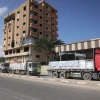 Trucks carrying aid drive on a road in Deir el-Balah after entering through the Kerem Shalom crossing in the southern Gaza Strip on October 17, 2025. Photo by BASHAR TALEB/AFP via Getty Images.