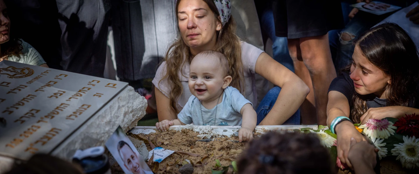 Anat Meir and her son, Shaked, mourn over the grave of Sayeret Matkal soldier David Meir, killed by Hamas terrorists on Oct. 7 at the battle on Kibbutz Be'eri, on the 30th day after his funeral at Mount Herzl Military Cemetery in Jerusalem, Nov. 8, 2023. Photo by Chaim Goldberg/Flash90.