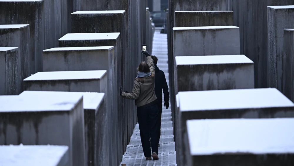 People walk and take photos among the snow-covered steles at the Holocaust Memorial in Berlin, Germany, on Jan. 27, 2026, during commemorations of the International Holocaust Remembrance Day. Photo by Ralf Hirschberger / AFP via Getty Images.