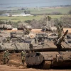 Israeli soldiers seen near IDF tanks stationed near the Israeli Gaza border on March 26, 2019. Credit: Yonatan Sindel/Flash90