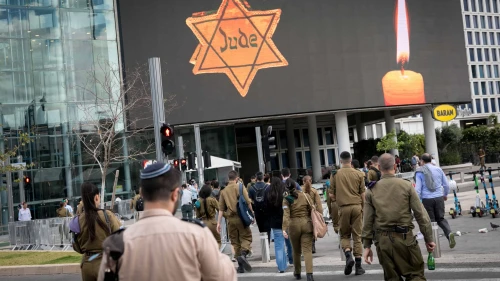 People walk by a Star of David reading "Jude" in Tel Aviv on Holocaust Remembrance Day. May 6, 2024. Photo by Miriam Alster/Flash90.