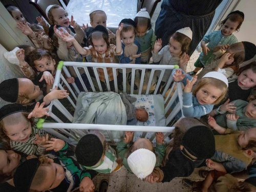 Boys in Jerusalem's ultra-Orthodox neighborhood of Mea She'arim recite the "Shema Yisrael" prayer in the presence of a week-old baby, a day before his circumcision ceremony, July 9, 2023. Photo by Chaim Goldberg/Flash90.