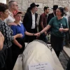 Ari Fuld's wife, Miriam, and son hold hands over his enshrouded body, wrapped in a tallit and awaiting burial at the Kfar Etzion cemetery in Judea. Photo by Gershon Elinson/Flash90.