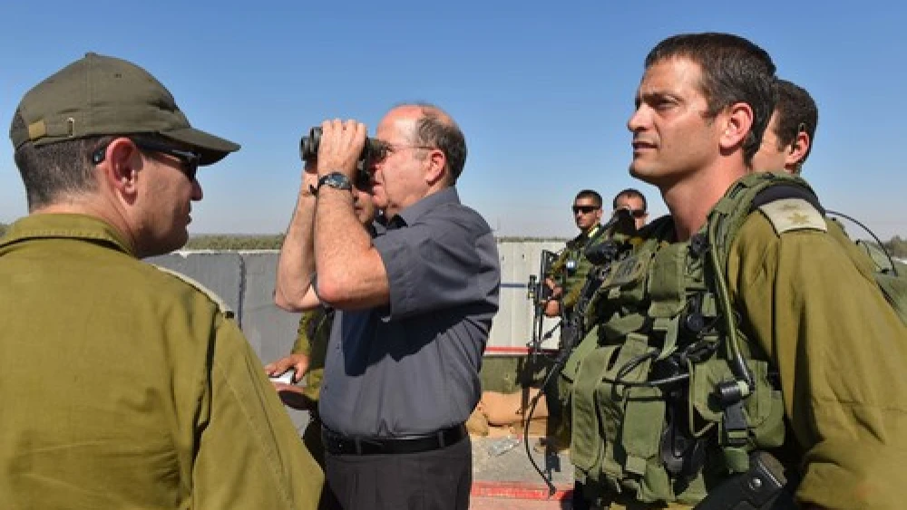 Click photo to download. Caption: Israeli Defense Minister Moshe Ya'alon (with binoculars) pictured during a visit to the Israel Defense Forces (IDF) Southern Command's Gaza Division on Tuesday. The IDF launched Operation Protective Edge in Gaza in response to escalated rocket fire by Hamas. Credit: Ariel Hermoni/Ministry of Defense/Flash90.