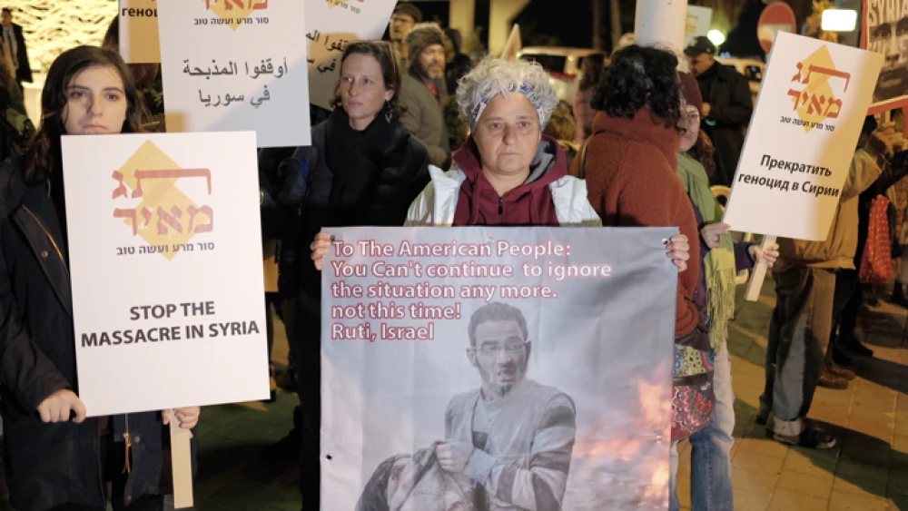 Protesters hold signs during a call to end the war in Syria near the Russian Embassy in Tel Aviv on Dec. 18, 2016. Photo by Tomer Neuberg/Flash90.