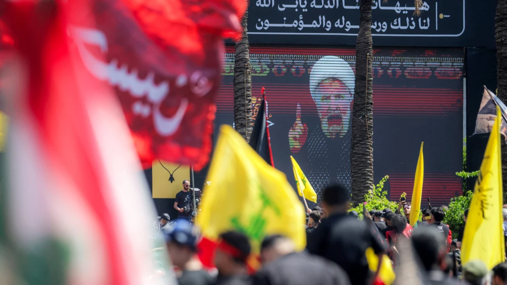 A crowd of Shia Muslim devotees watches as a televised speech by Naim Qassem, leader of terrorist organization Hezbollah, is displayed on a screen during a religious mourning event in Beirut's southern suburbs on June 26, 2026. Photo by Ibrahim Amro/AFP via Getty Images.