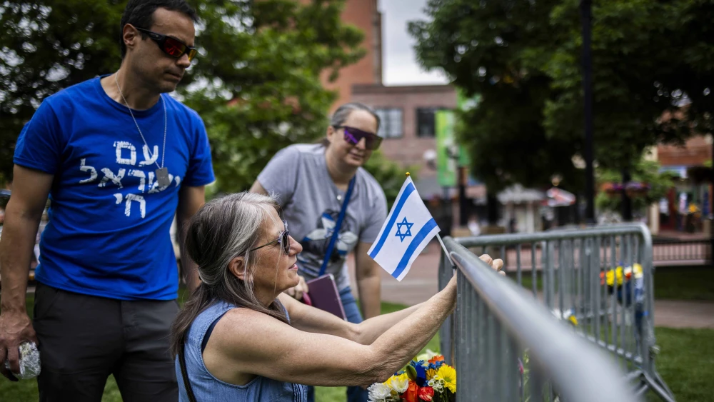 Lisa Turnquist of Louisville, Colo., lays flowers and an Israeli flag at the site where 12 people were wounded in a Molotov cocktail attack during a pro-Israel rally outside the Boulder County Courthouse on June 2, 2025. Photo by Chet Strange/Getty Images.