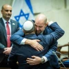 Knesset Speaker Amir Ohana (facing the camera) and Minister of National Security Itamar Ben-Gvir embrace at the swearing-in ceremony for the Netanyahu government at the Knesset in Jerusalem, Dec. 29, 2022. Photo by Yonatan Sindel/Flash90.