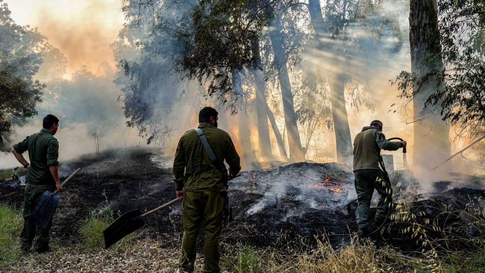 Members of an emergency squad try to extinguish a fire caused by rockets fired from Lebanon, near the northern Israeli town of Kiryat Shmona, June 4, 2024. Photo by Ayal Margolin/Flash90.
