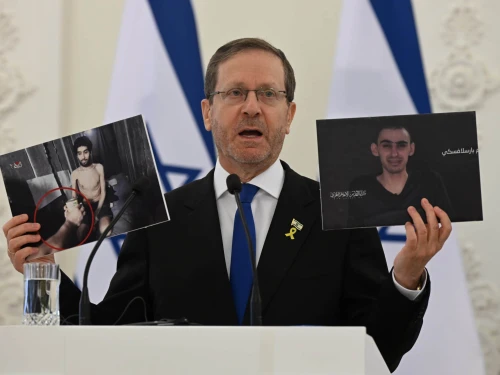 Israeli President Isaac Herzog holds pictures of hostages Evyatar David (left) and Rom Braslavski during a press conference in Vilnius, Lithuania, Aug. 4, 2025. Photo by Haim Zach/GPO.