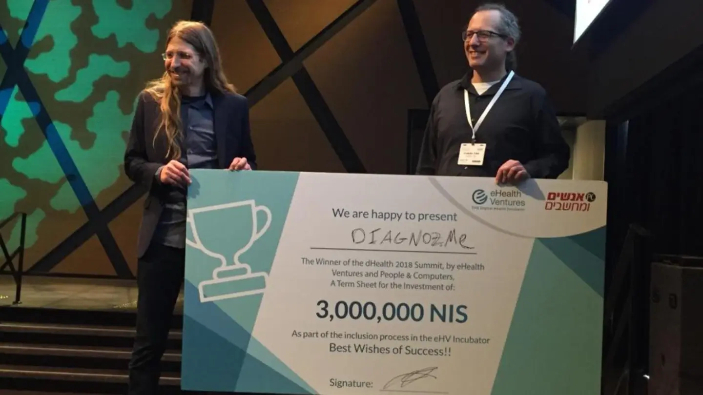 Diagnoz.me founders Ariel Livne and Tamir Epstein accepting their NIS 3 million (nearly $830,000) prize money at the dHealth 2018 Summit. Credit: Courtesy of Israel21c.