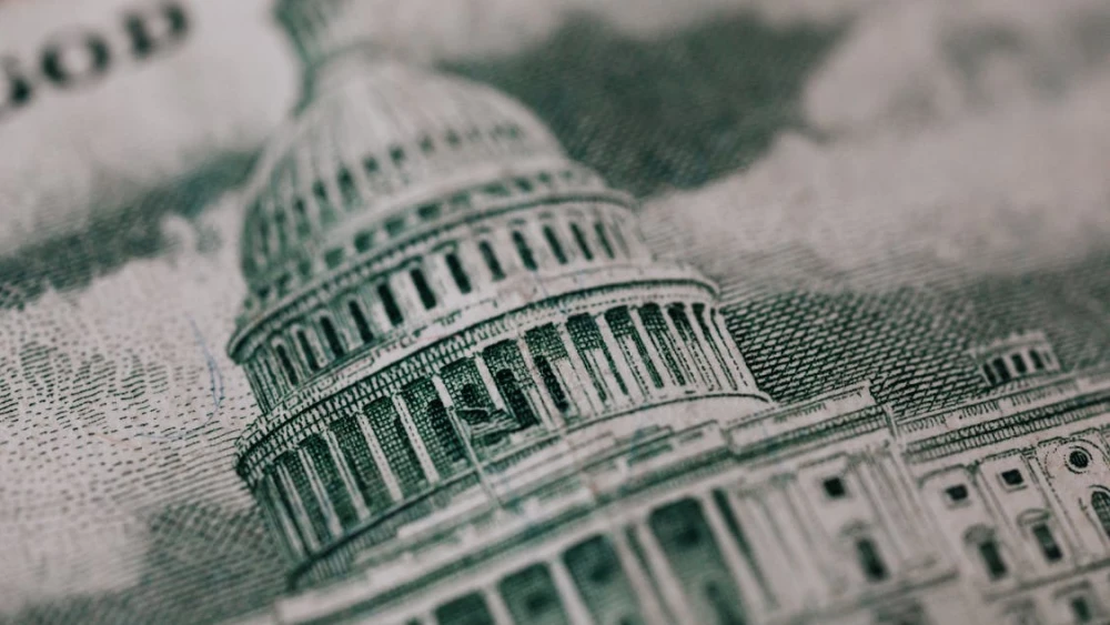 U.S. Capitol building in backdrop of American money. Credit: Karolina Grabowska via Pexels.