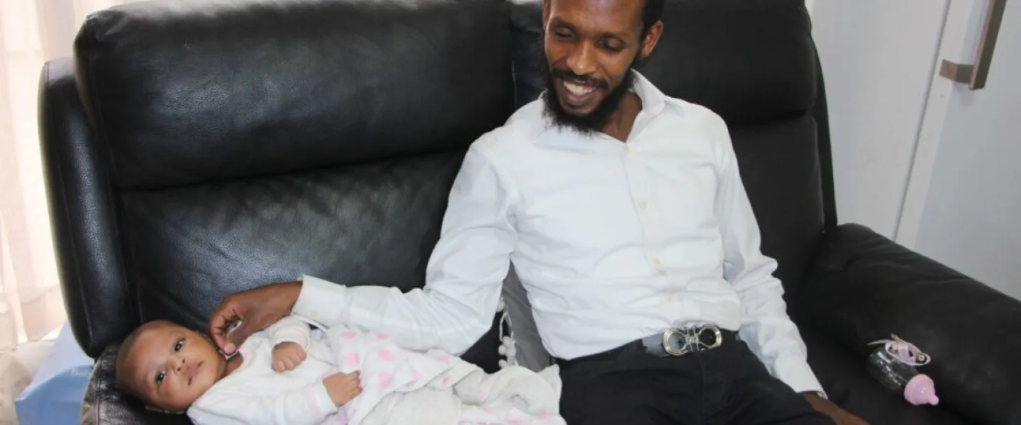 Avi Solomon with his seventh child, Malka. Photo by Judith Sudilovsky.