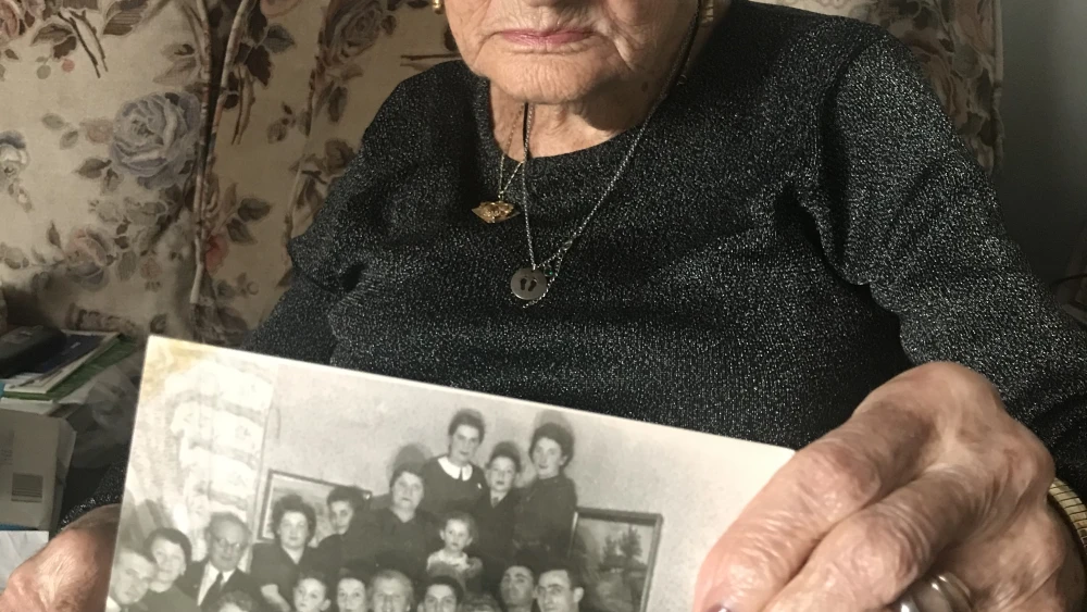 Mira displaying a picture of her extended family, most of whom perished in the Holocaust. Credit: Courtesy.