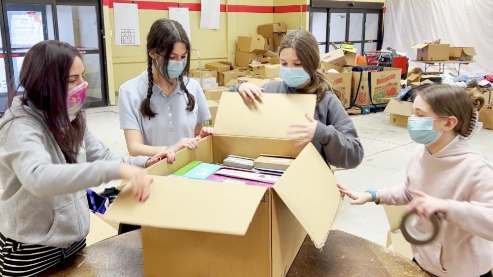 Ms. E, Shirel, Chloe and Orly separating shoes at the Project Friendship Warehouse. Credit: Courtesy.