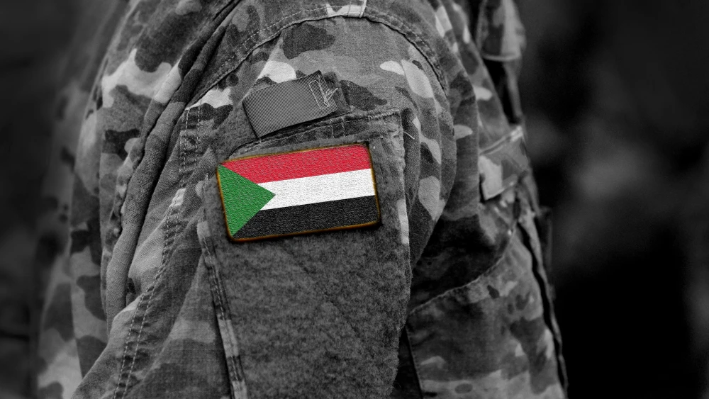 Sudan flag on a military uniform. Credit: Bumble Dee/Shutterstock.