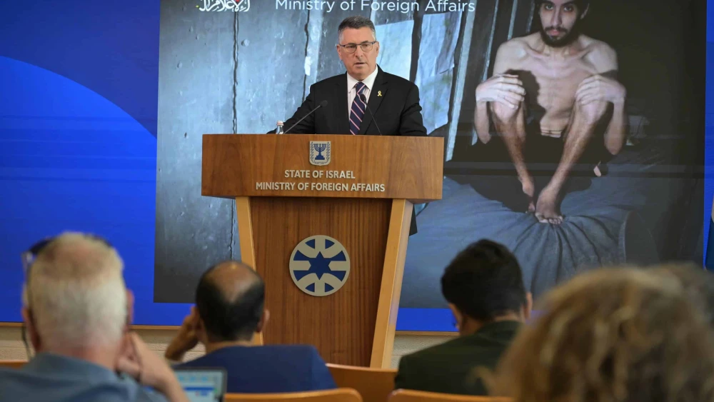 Foreign Minister Gideon Sa’ar speaks to foreign reporters in Jerusalem, standing before an image of Hamas captive Evyatar David, Aug. 4, 2025. Photo by Shlomi Amsalem/GPO.