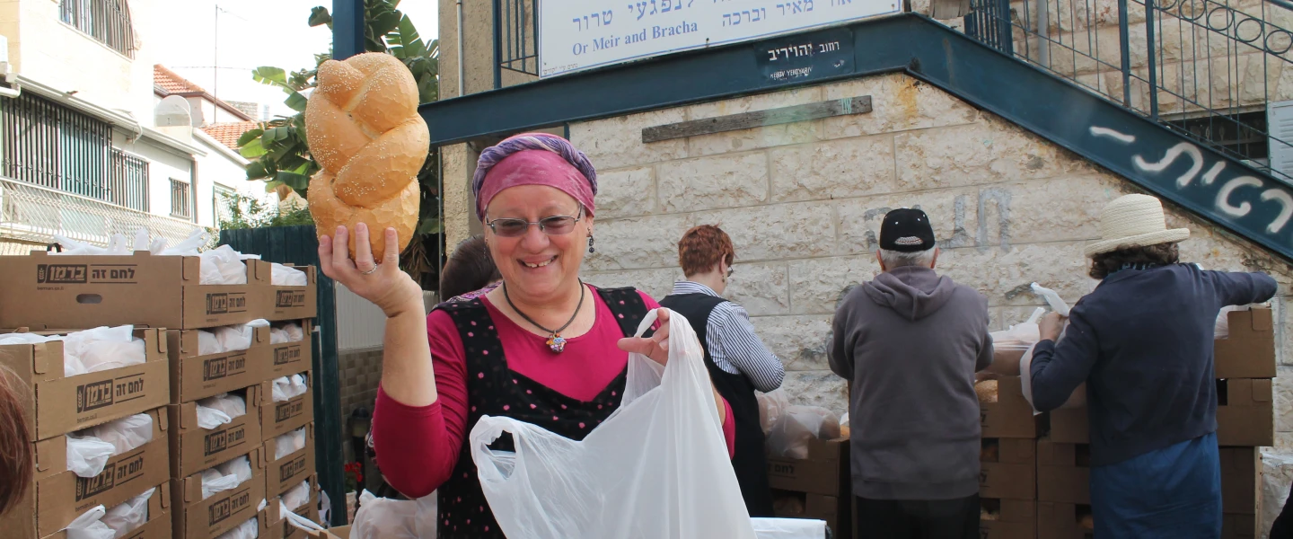 Volunteer Rita Lewy displays a loaf of challah at the Terror Victims Support Center. Credit: Courtesy.