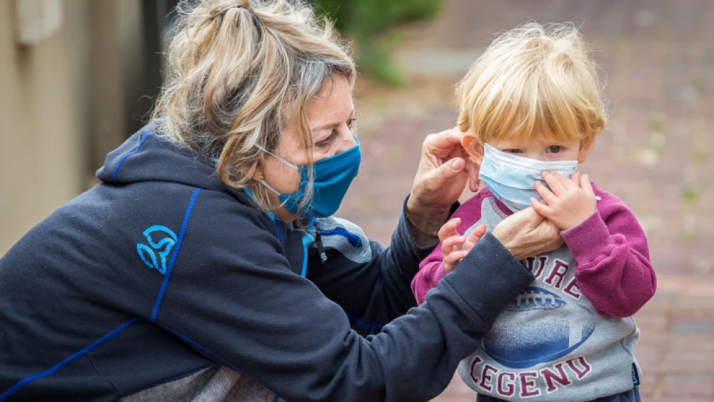 A toddler visits his grandmother at her home in Haniel, a moshav in central Israel, on April 5, 2020. Photo by Chen Leopold/Flash90.
