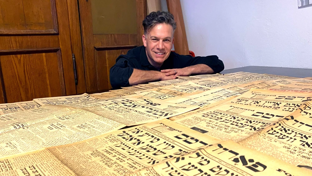 Dan Wyman with a set of 1945 Yiddish Daily Forward issues. Courtesy: Dan Wyman