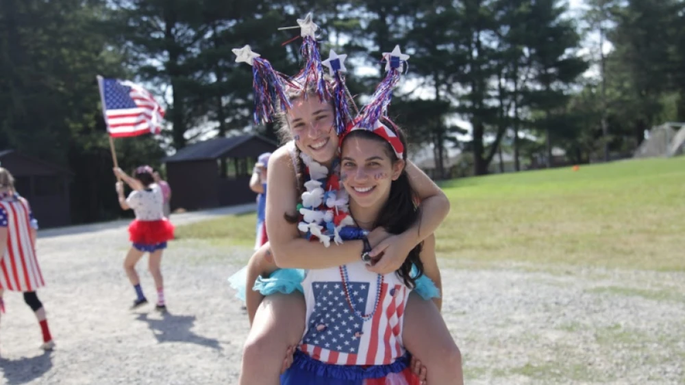 Aviva Weinstein (front) marking the Fourth of July with a friend at summer camp. Credit: Courtesy.