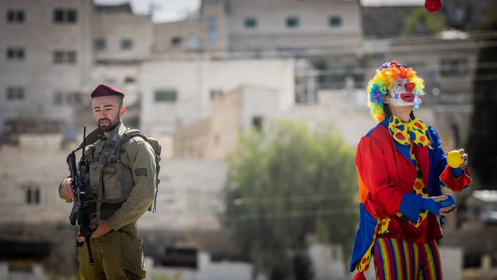 A clown practices before taking part in the annual parade marking the Jewish holiday of Purim in Hebron on March 7, 2023. Photo by Yonatan Sindel/Flash90.