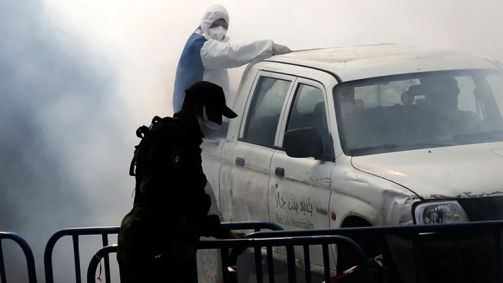A Palestinian municipal employee disinfects a street at the entrance to the West Bank city of Bethlehem on March 12, 2020. Photo by Wisam Hashlamoun/Flash90.
