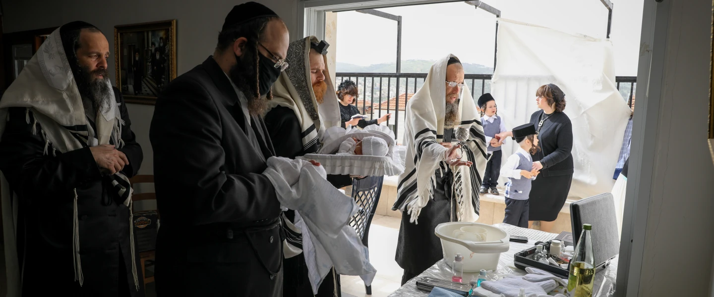 The Greenfeld family celebrate a brit milah at their home in Beitar Illit, Israel, on April 5, 2020. Photo by Nati Shohat/Flash90.