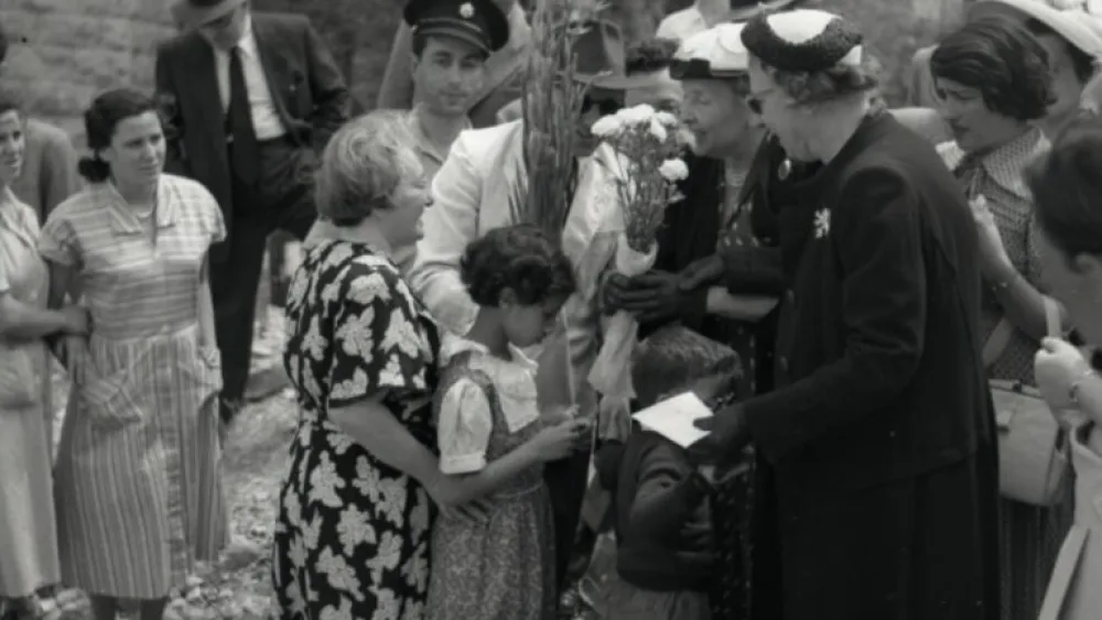 Helen Keller is greeted with flowers at Kfar Uriel, 1952. Photo by Benno Rothenberg, the Meitar Collection/Archives of the National Library of Israel.