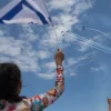 People at Bugrashov Beach in Tel Aviv watch the military airshow on Israel's 71st Independence Day, May 9, 2019. Photo by Hadas Parush/Flash90.