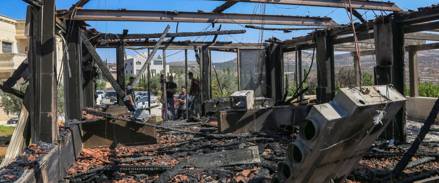 Palestinians inspect a house that was set on fire and spray-painted with graffiti during an attack by a group of extremist Jewish settlers in the village of Osarin on Aug. 23, 2026. Photo by Nasser Ishtayeh/Flash90.