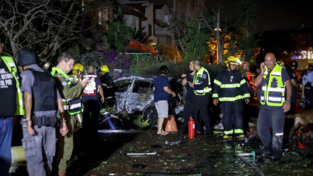 Police and rescue personnel at the scene of a building in Rishon Letzion that was directly hit by a rocket fired from the Gaza Strip, leaving one Israeli dead. More than 130 rockets were fired from Gaza into central Israel on May 11, 2021. Photo by Noam Revkin Fenton/Flash90.