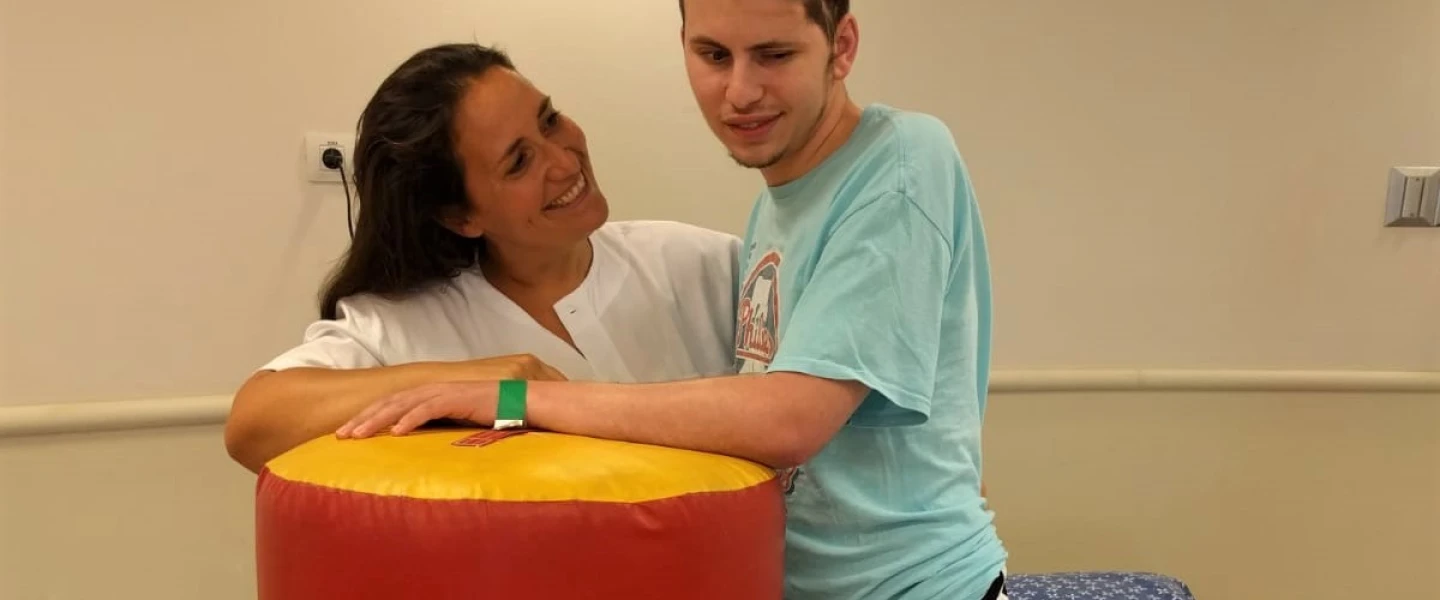 Dr. Adi Gidali, a New York-trained physical therapy supervisor at the Outpatient Brain Injury Unit at Sheba Medical Center, with 24-year-old recovering patient Netanel Felber. Credit: Sheba Medical Center.