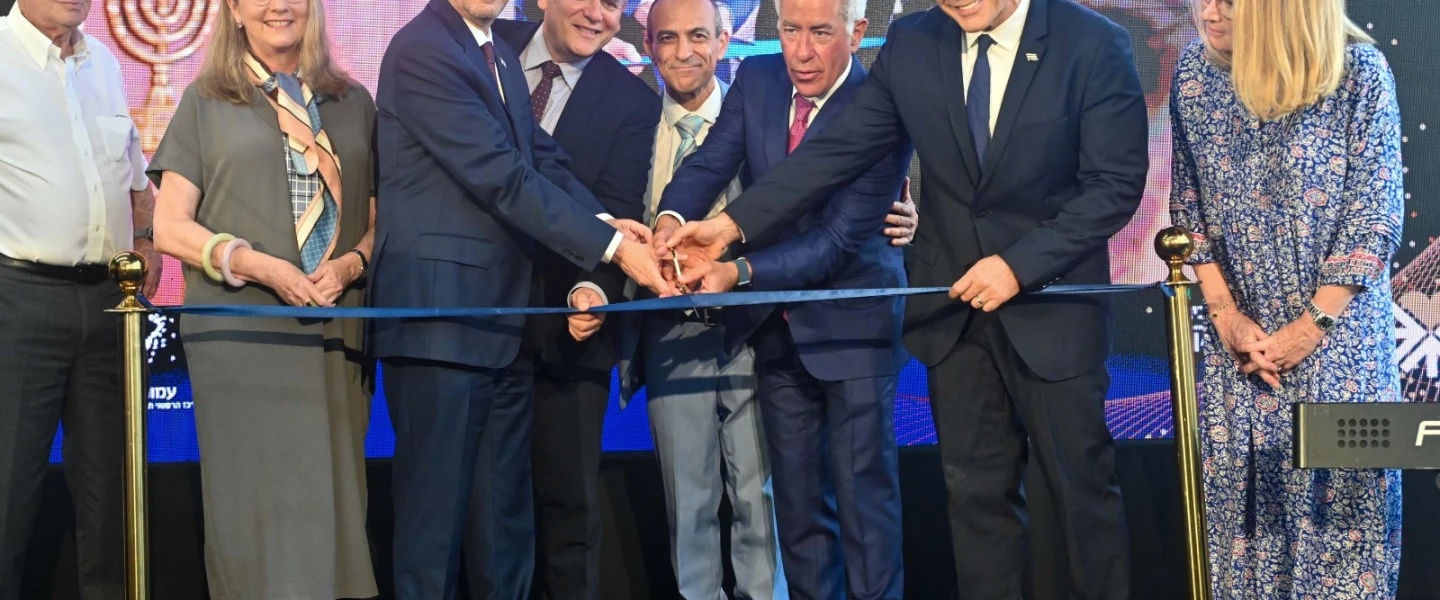 Israeli-Canadian businessman Sylvan Adams (third from right) cuts the ribbon to inaugurate the Sylvan Adams Emergency Hospital along with Israeli Prime Minister Yair Lapid (second from right) and Israeli President Isaac Herzog (third from left), together with other dignitaries, July 28, 2022. Credit: Jenny Yerushalmi.