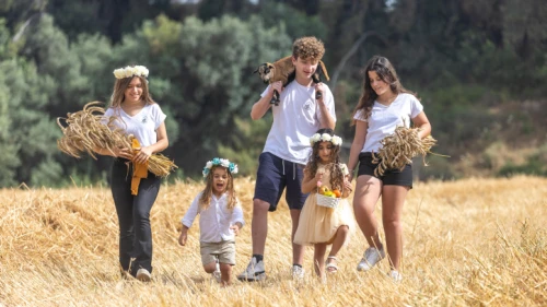 Young Israelis from Ben Shemen pose for a picture in a harvest field ahead of Shavuot, on May 18, 2023. Photo by Yossi Aloni/Flash90.