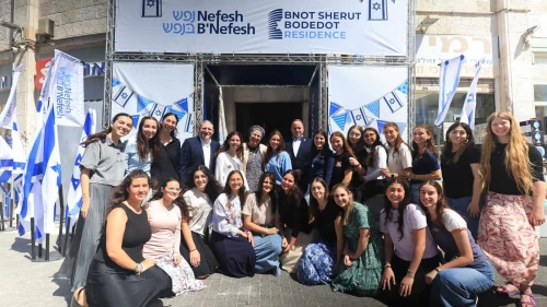 Young women volunteering in Israel's National Service pose for a photograph at the entrance to the new Nefesh B'Nefesh Bnot Sherut Bodedut Residence, Sept. 7, 2025. Photo by Yonit Schiller.