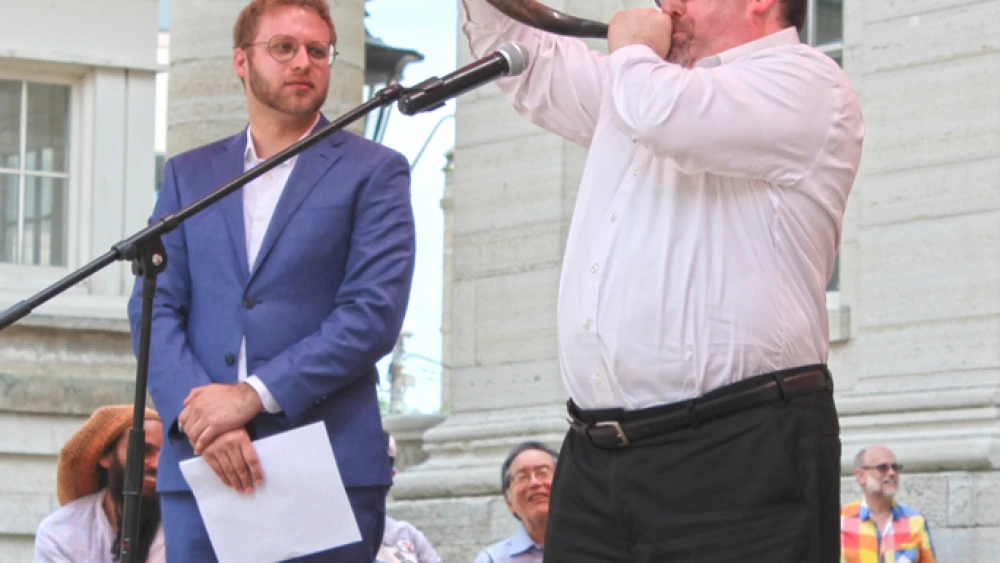 At Dayton’s Courthouse Square the day after the Klan rally, Beth Abraham Synagogue’s Rabbi Josh Ginsberg sounds the shofar ‘to wake us from our moral slumber’ as Temple Beth Or’s Rabbi Ari Ballaban, director of Dayton’s Jewish Community Relations Council, looks on. The two participate in NAACP’s ritual cleansing of the square, May 26, 2019. Credit: Marshall Weiss.