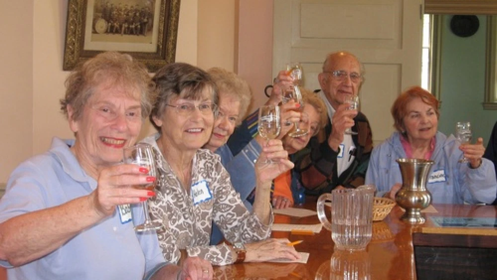 Community members make a toast at the St. Louis NORC ( Naturally Occurring Retirement Community). A group of Jewish federations started NORC communities in response to a federal initiative to develop replicable models to deal with the coming increase in the senior population. Credit: St. Louis NORC.