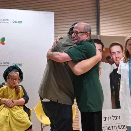 Shalom Yaniv (left), father of terror victims Hallel and Yagel Yaniv, hugs Ron Carmeli, who received a donated cornea, at Beilinson Hospital in Petach Tikvah, June 18, 2023. Photo by Yossi Zeliger/TPS.