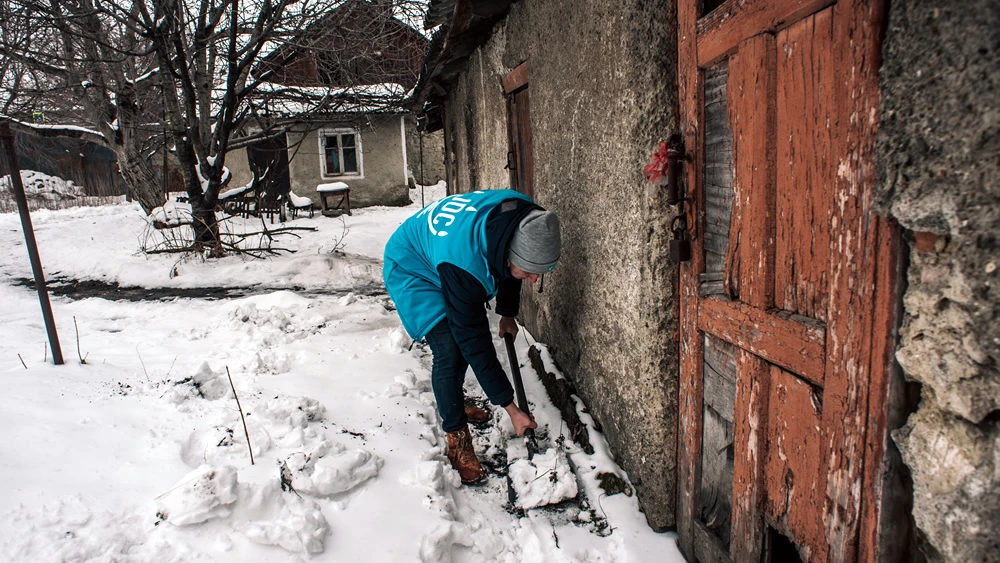 A Jewish volunteer—one of thousands trained by the American Jewish Joint Distribution Committee’s volunteer centers in the former Soviet Union, a partnership with the Genesis Philanthropy Group—shovels snow outside a Jewish senior's residence in the northern Moldovan city of Bălți. Credit: Photo by Arik Shraga/JDC.
