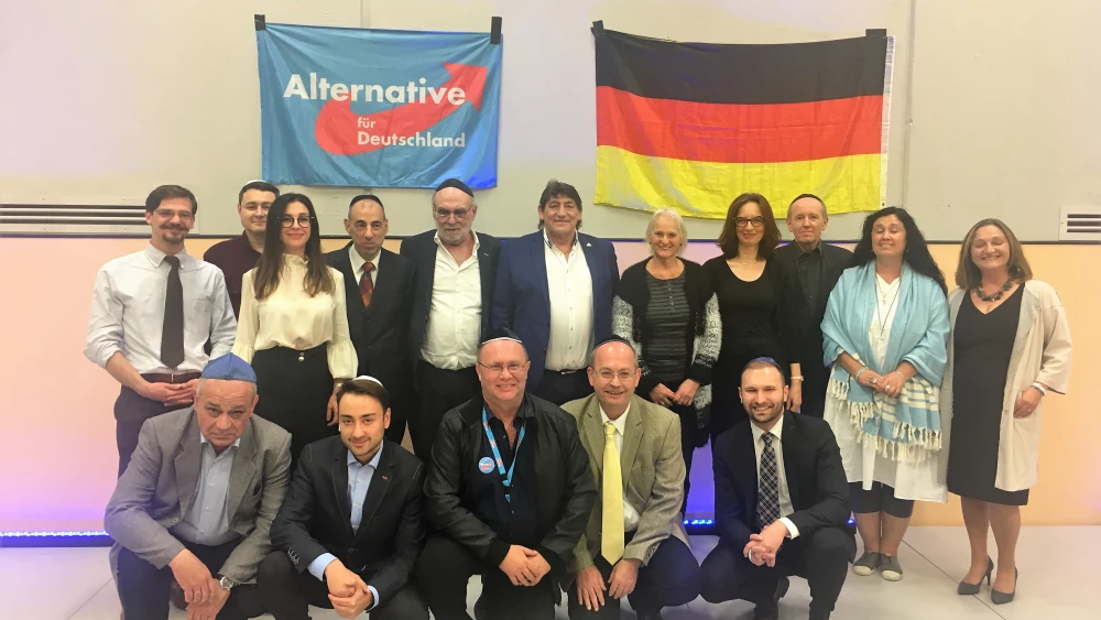 Members of the Jewish faction to Germany's AfD pose in front a party flag and the German flag. Credit: Orit Arfa.