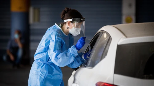 Shaare Zedek medical worker wearing protective clothing takes a swab from a woman to test for the coronavirus disease (COVID-19), outside the coronavirus unit at Shaare Zedek Hospital in Jerusalem on Sept. 10, 2020. Photo by Yonatan Sindel/Flash90.