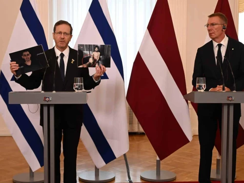 Israeli President Isaac Herzog holds up images of Israeli hostages Evyatar David and Rom Braslavski as Latvian President Edgars Rinkēvičs looks on during their joint press conference in Riga, Latvia, on Aug. 5, 2025. Photo: Haim Zach/GPO.