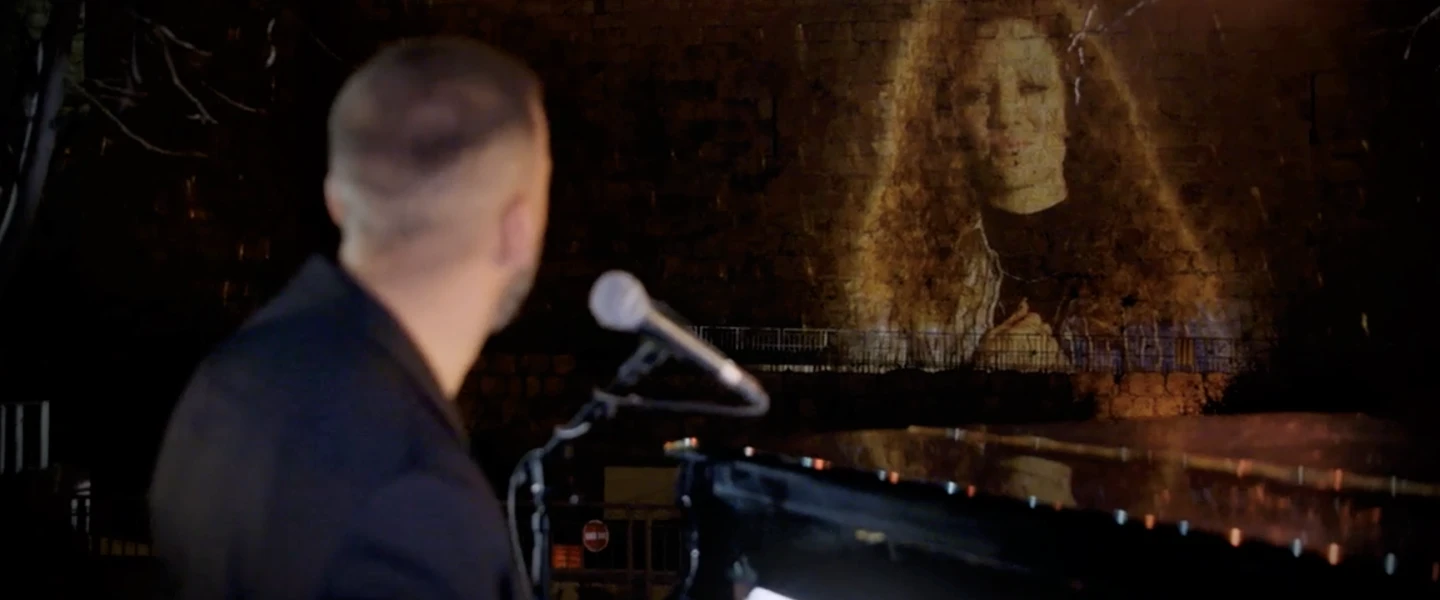 An image of British singer Jess Glynne projected on the walls of Jerusalem’s Old City, as she and Israeli musician Idan Raichel perform during “Illuminate: A Global Jewish Unity Event,” to celebrate the Declaration of Our Common Destiny and Israeli President Reuven Rivlin’s endorsement, Dec. 17, 2020. Credit: Courtesy.