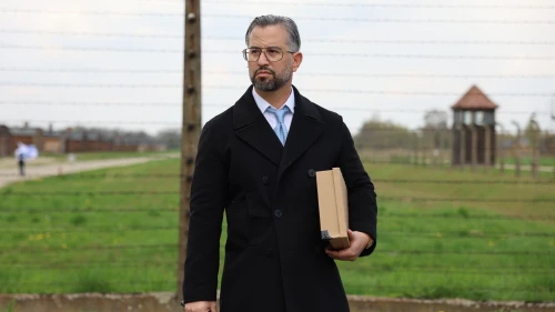 Eitan Neishlos holds his grandmother’s shoebox at Auschwitz-Birkenau during the 2022 March of the Living. Photo by Tali Natapov/Neishlos Foundation.